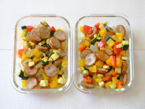 rectangular glass meal prep containers with sliced sausage and diced zucchini, bell peppers, and red onions