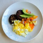 Turkey Sausage Patties with scrambled eggs, diced potatoes and bell peppers, and sliced avocado
