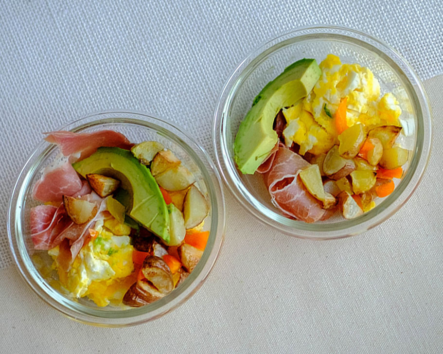 scrambled eggs with prosciutto, avocado slices, and roasted bell peppers and potatoes